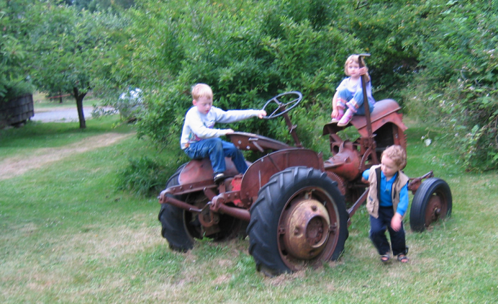 kids playing on tractor at the Cardboard House Cafe, Hornby Island