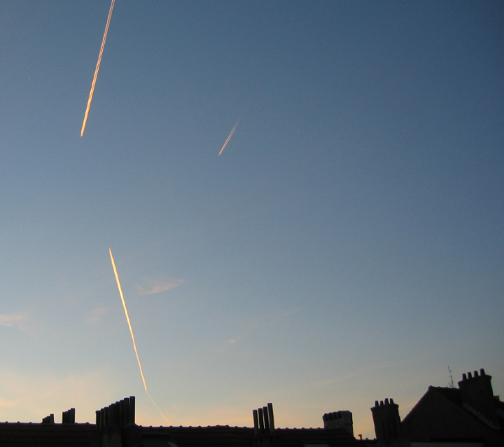 Vapor trails over a Brussels skyline