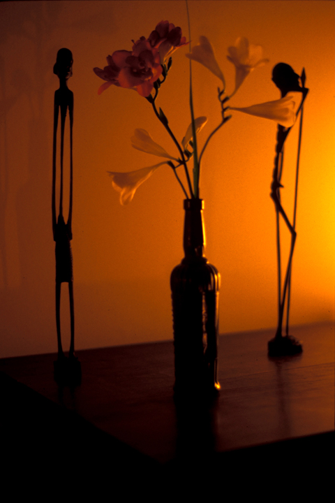 Two african figurines and flower arrangement