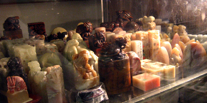 Chinese figurines in dusty display case