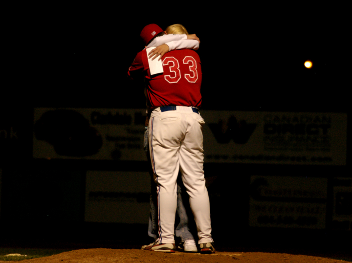 Baseball player kisses his new fiance on the pitcher’s mound
