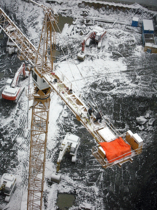 Construction workers on high snowy crane