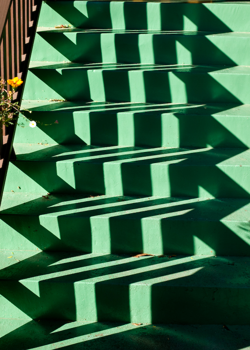 Green steps with railing shadows