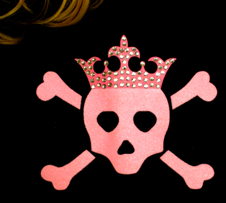 Skull and crossbones in pink, with sequined crown and a lock of blonde hair