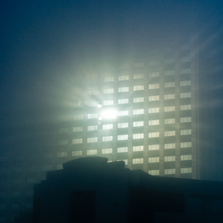 Morning sun reflecting off building in fog.