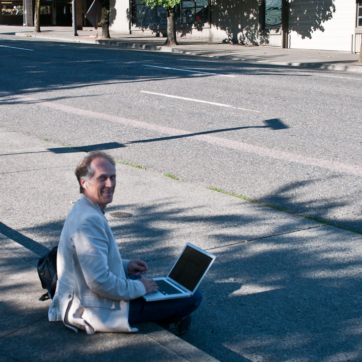 Tim O’Reilly sitting on curb with laptop