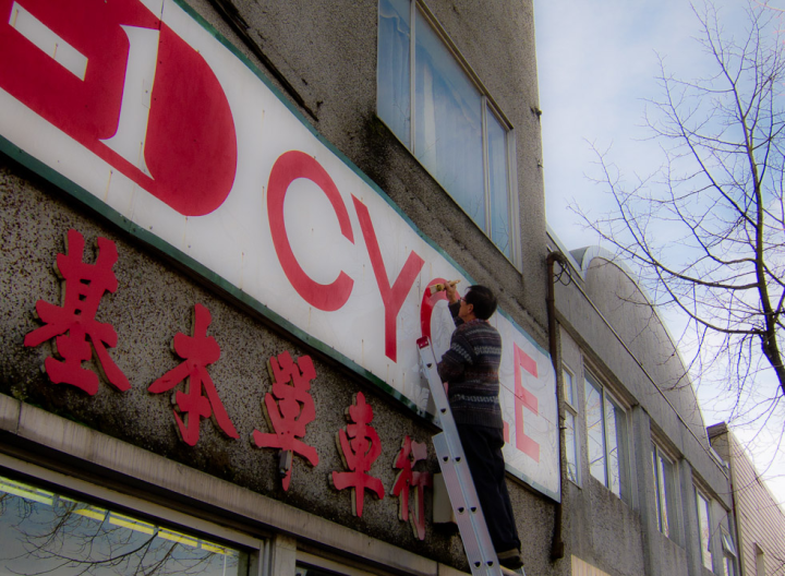 Man repainting a sign at A-1 Cycle shop