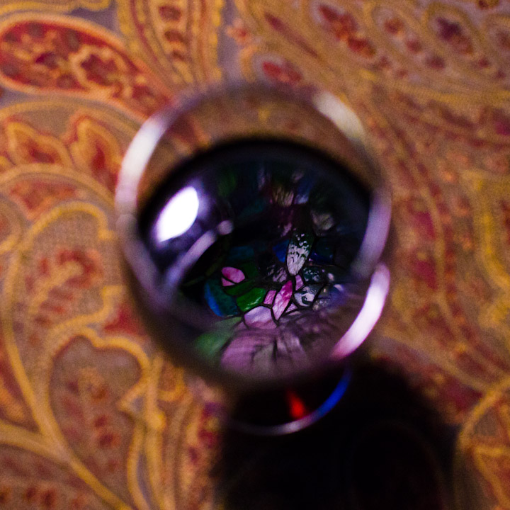 Tiffany lamp reflected in a glass of red wine