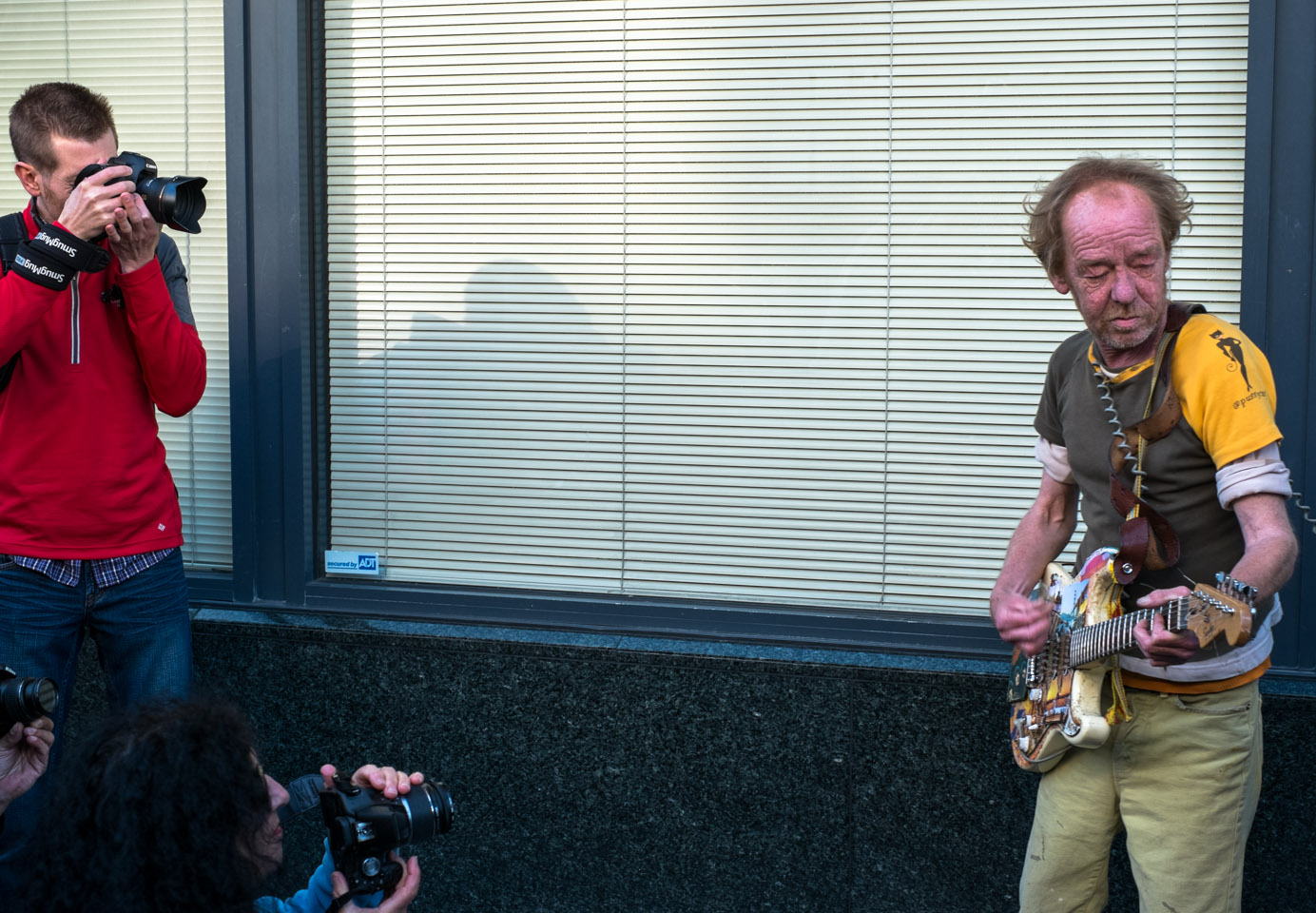 Street guitarist being photographed