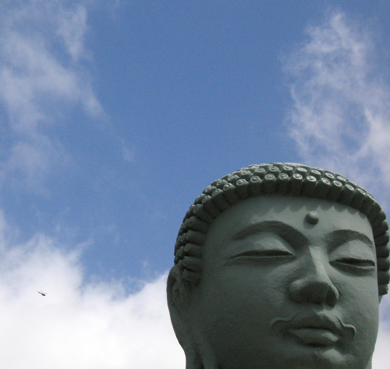 Image of Buddha in the Lahaina Buddhist mission, with helicoper 