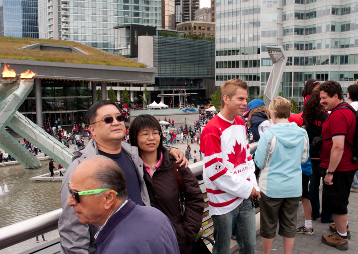 People having their picture taken on Canada Day by Vancouver’s Olympic flame
