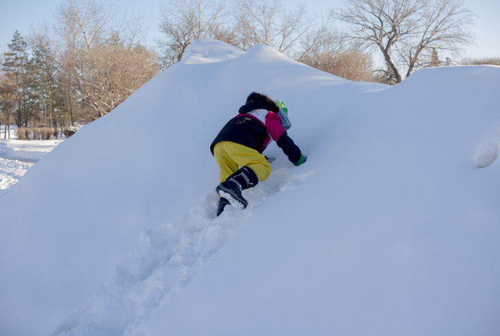 Child climbs snow-bank