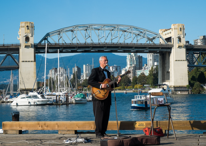Busker at Granville Island with False Creek in the background