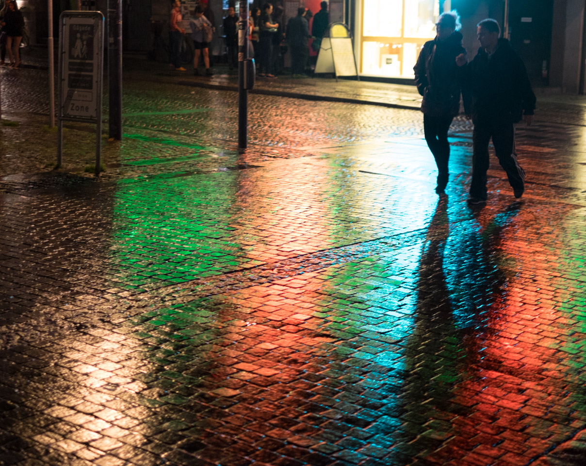 Bright lights on wet cobblestones in Copenhagen