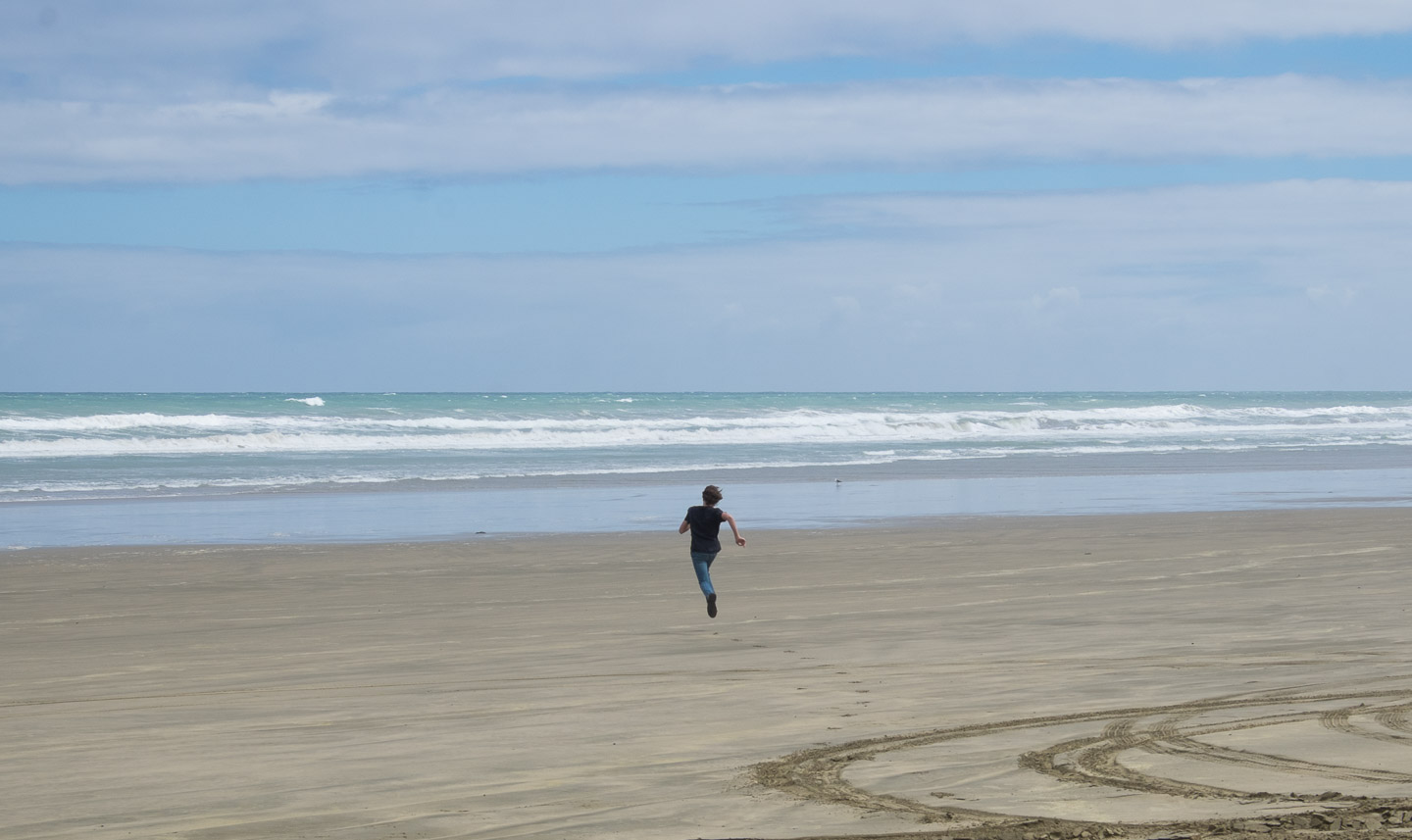 Boy jumping on Ninety Mile Beach