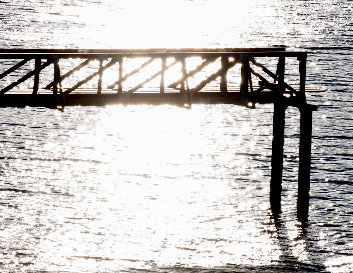 Dock with sun behind it