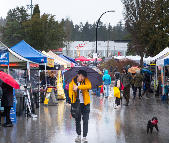 People shopping in the rain at the Riley Park Winter Market in Vancouver