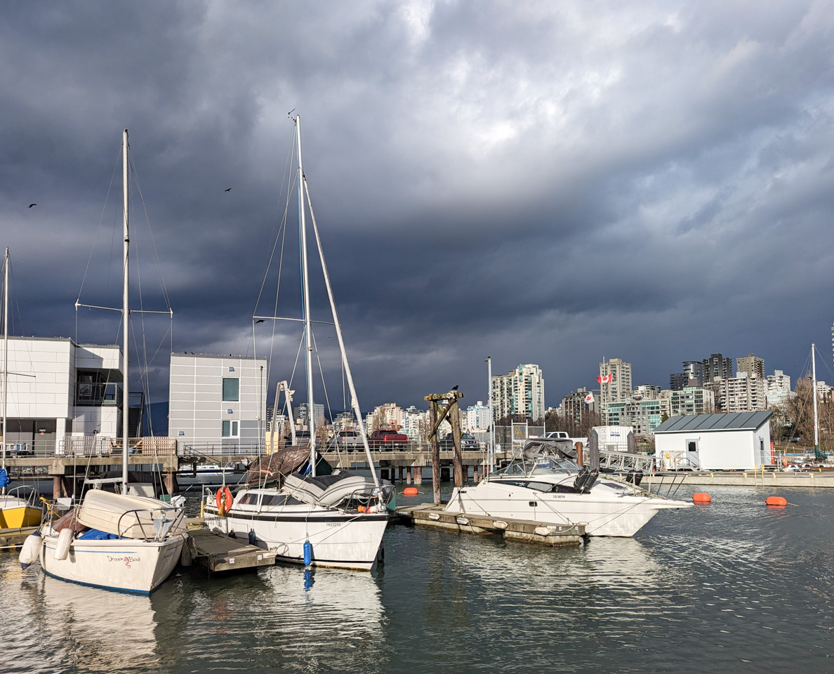 Brightly-lit boats on dark water under a dark sky