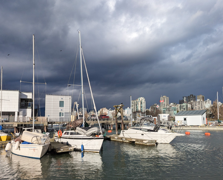 Brightly-lit boats on dark water under a dark sky