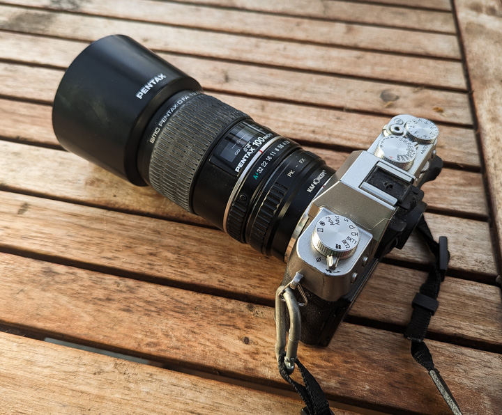 Pentax 100mm macro lens strapped on Fujifilm X-T30