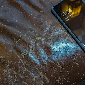 Worn leather with a phone for scale