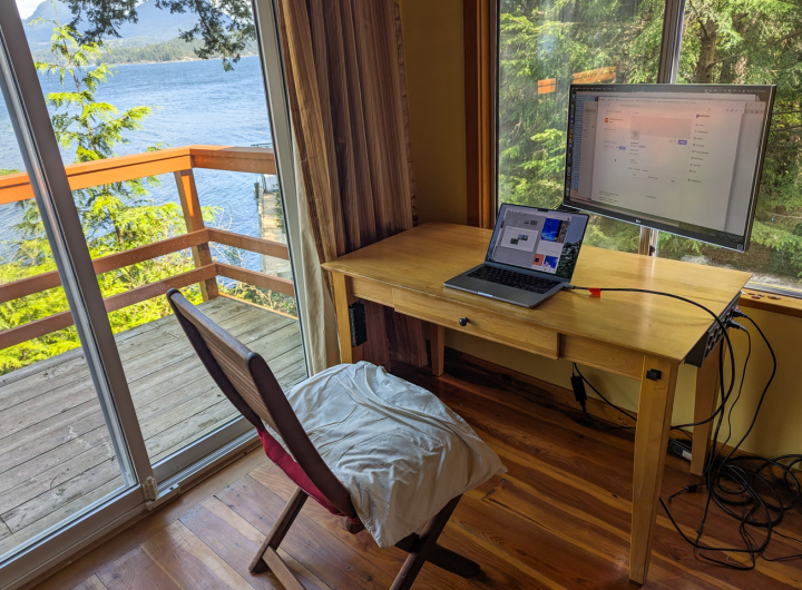 A desk with a computer and outboard monitor and really great views