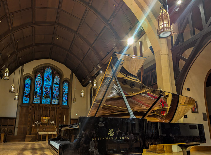 Grand piano by itself in an old church