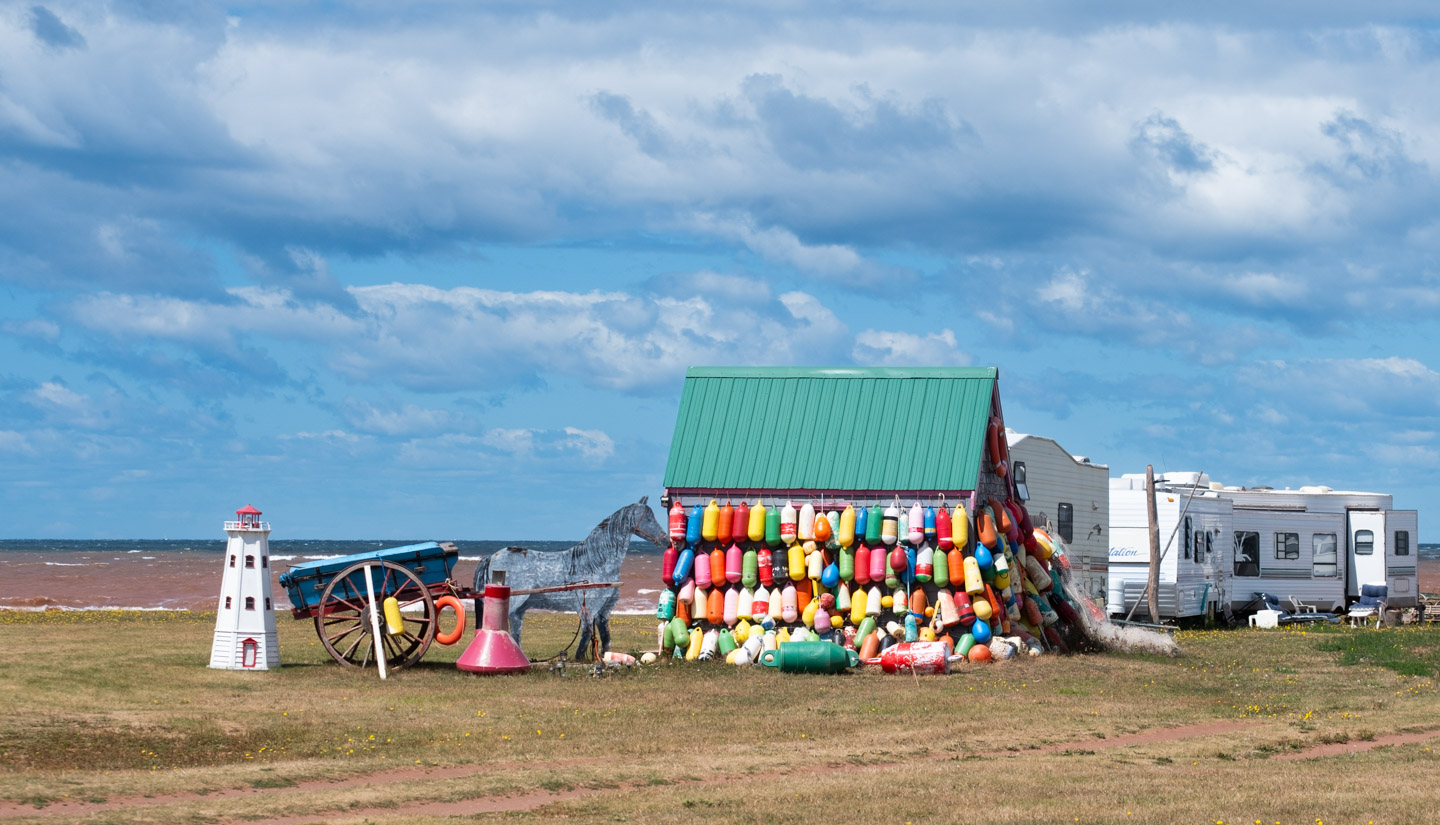 A trailer park with small building covered by bright colored fenders