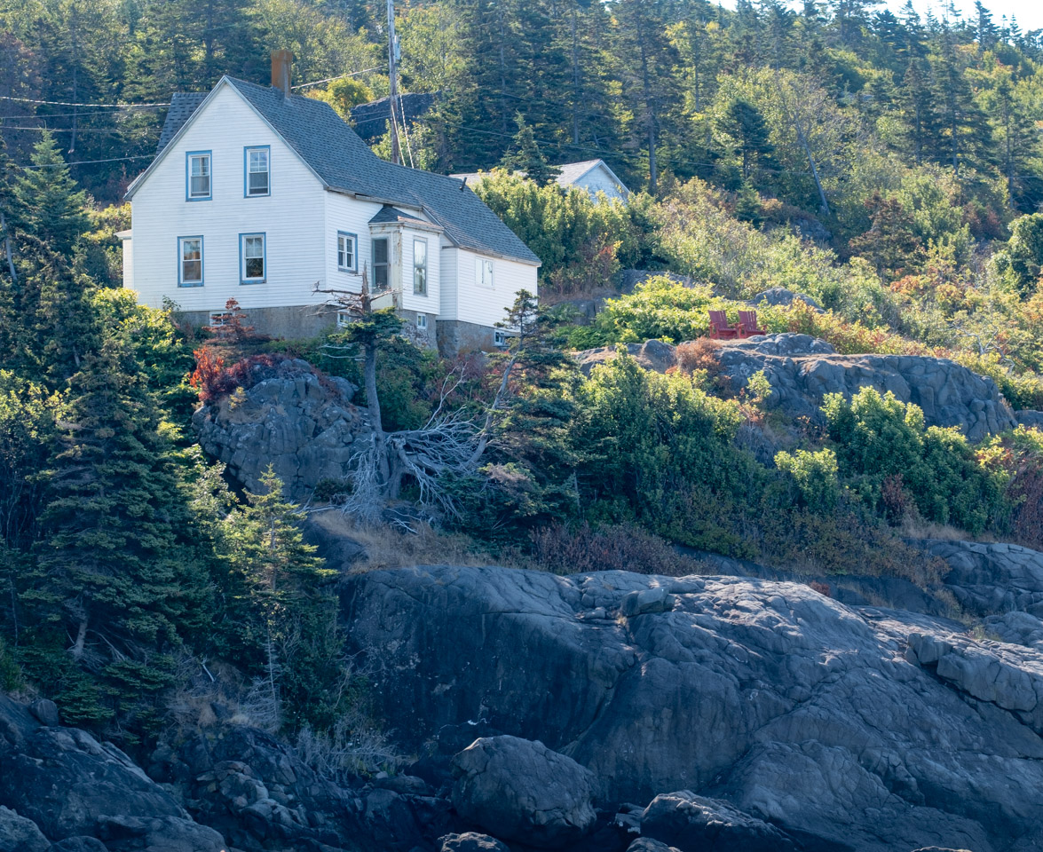 A white house perched on rocks above the sea-side