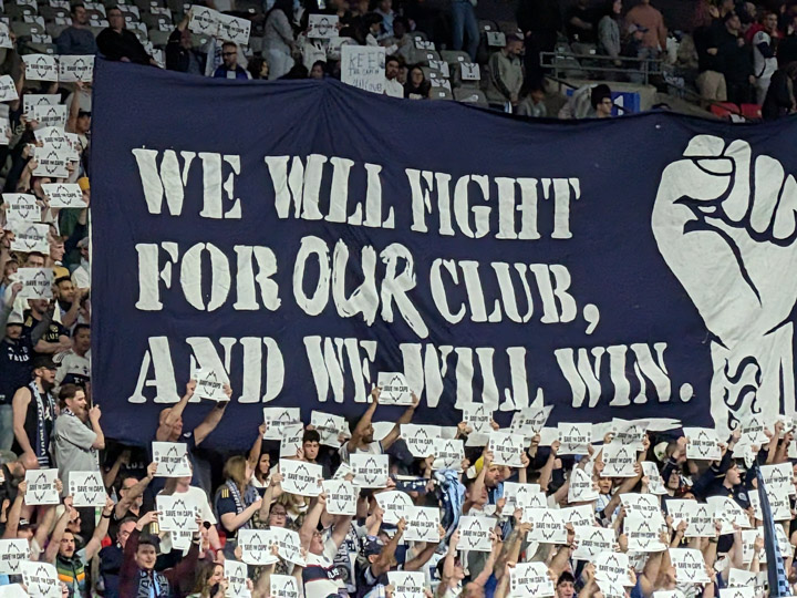 Fans with a “Save the Caps” message