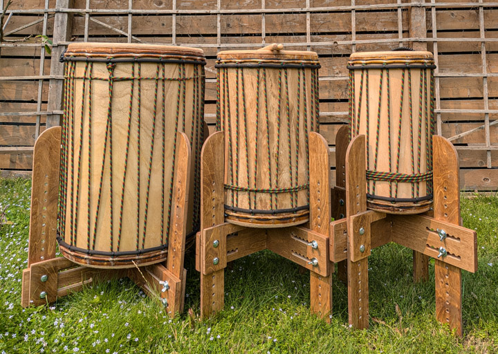 Three dununs on ballet-style stands on uncut grass